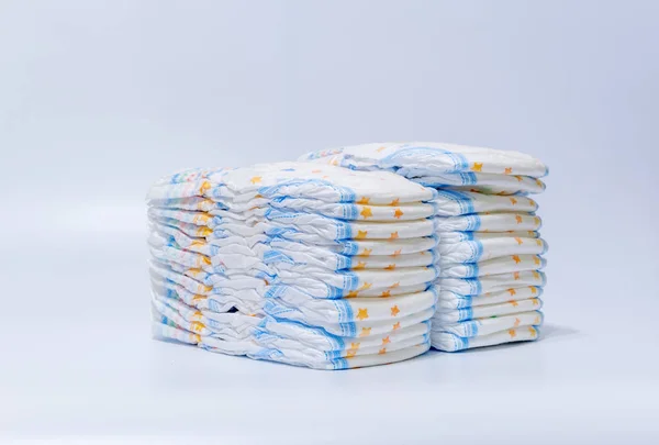 Pilhas de fraldas empilhadas em linhas escalonadas em um fundo branco — Fotografia de Stock