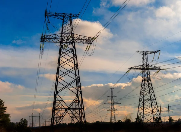 Pilones y líneas eléctricas al atardecer al atardecer . —  Fotos de Stock