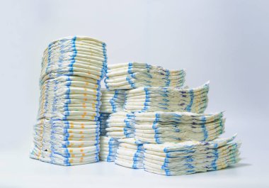 Çocuk bezi beyaz bir arka plan üzerinde sendeleyerek satırlardaki yığılmış yığını