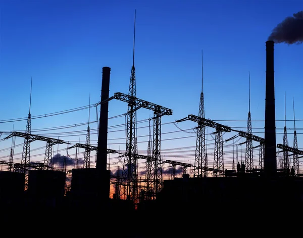 distribution electric substation with power lines and transformers, at sunset