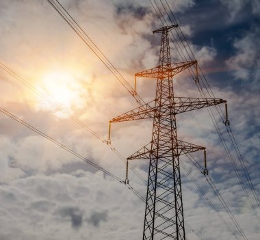 Günbatımında yüksek voltajlı elektrik hatları. Elektrik dağıtım istasyonu. yüksek voltajlı elektrik iletim kulesi