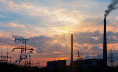 Gün batımı sırasında baca ile endüstriyel enerji santrali.
