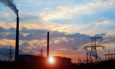 Elektrik hatları ve trafolar olan elektrik santralini gün batımında dağıtın..