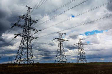 Elektrik direkleri ve gün batımında alacakaranlıkta çizgiler.