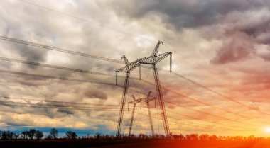 Gün batımında yüksek voltajlı elektrik hatları. Elektrik dağıtım istasyonu .