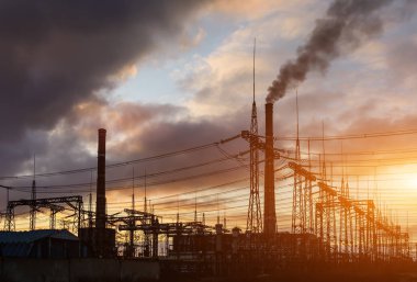 gaz türbini elektrik santrali ile turuncu gökyüzü alacakaranlıkta.