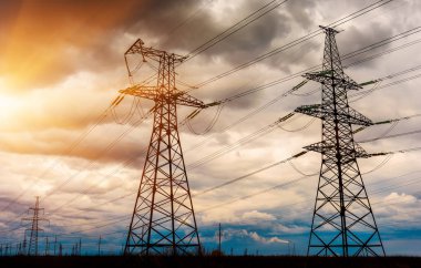 Gün batımında yüksek voltajlı elektrik hatları. Elektrik dağıtım istasyonu.
