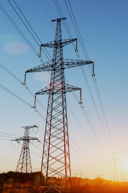 Mavi gökyüzüne karşı yüksek voltajlı elektrik hatlarını destekliyor. Elektrik endüstrisi.