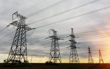 Günbatımında yüksek voltajlı elektrik hatları. Elektrik dağıtım istasyonu. yüksek voltajlı elektrik iletim kulesi