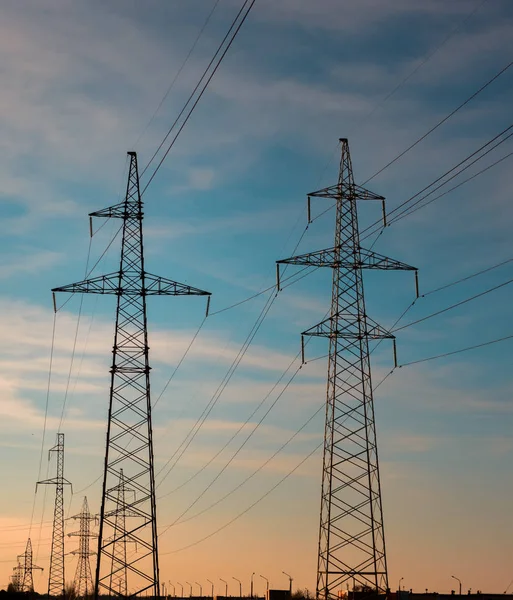 Günbatımında yüksek voltajlı elektrik hatları. Elektrik dağıtım istasyonu. yüksek voltajlı elektrik iletim kulesi.