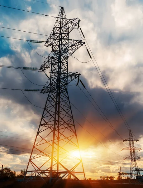 Günbatımında yüksek voltajlı elektrik hatları. Elektrik dağıtım istasyonu. yüksek voltajlı elektrik iletim kulesi.