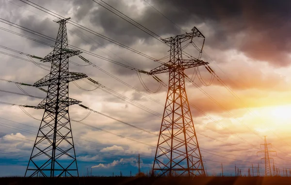 Yüksek voltajlı elektrik iletim ve fırtınalı gökyüzü güneş ışınları ile çizgilerdir.