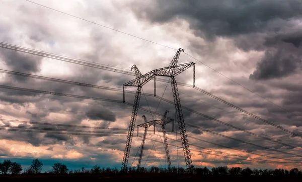 Turuncu günbatımında elektrik direkleri