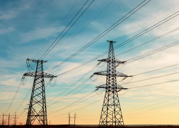 Günbatımında yüksek voltajlı elektrik hatları. Elektrik dağıtım istasyonu. yüksek voltajlı elektrik iletim kulesi