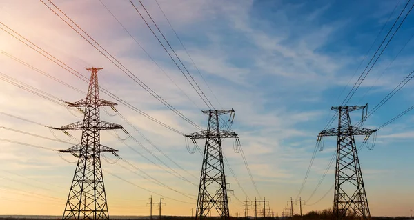 Líneas de alimentación eléctrica al ponerse el sol en el fondo —  Fotos de Stock