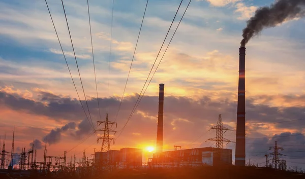 Emissões de centrais elétricas vistas acima de blocos residenciais de uma cidade durante o nascer do sol — Fotografia de Stock