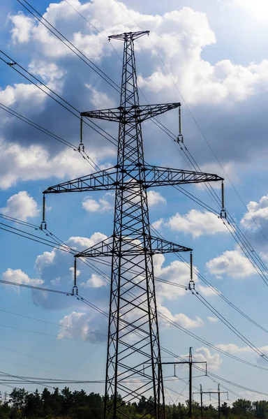 Elettricità pilone sagomato sullo sfondo cielo blu. Torre ad alta tensione — Foto Stock