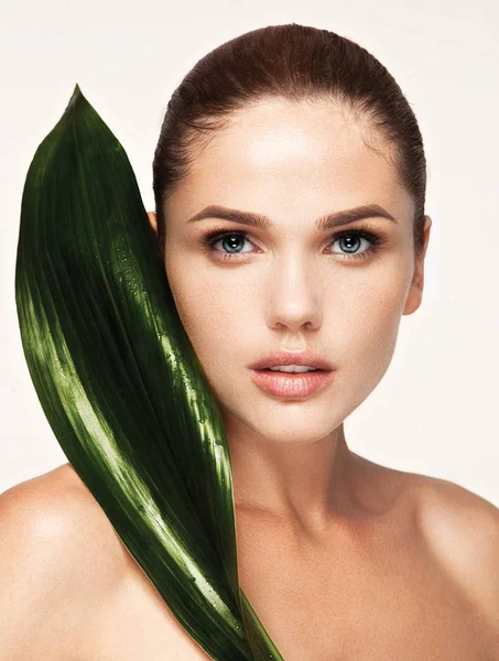 Beautiful woman face portrait with green leaf — Stock Photo, Image