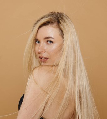 Stüdyoda çıplak arka planda poz veren güzel sarışın kadın portresi.