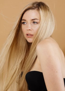 Stüdyoda çıplak arka planda poz veren güzel sarışın kadın portresi.