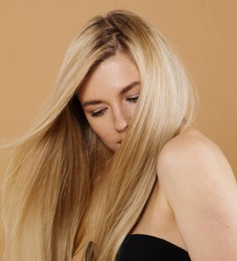 Stüdyoda çıplak arka planda poz veren güzel sarışın kadın portresi.