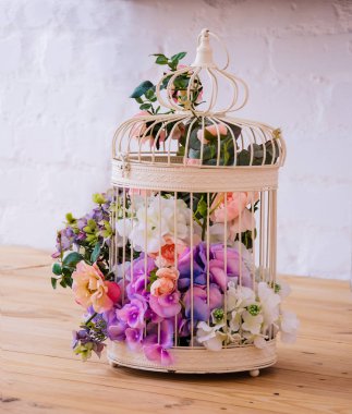 Renkli çiçeklerle kuş kafesi