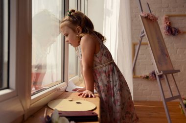 Küçük kız penceresinin içine arıyorum