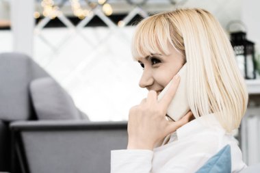 gülümseyen ve bir cep telefonu üzerinde konuşurken genç kadın