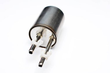 Yeni bir yakıt filtresi, beyaz arka planda yakıt borularının giriş ve çıkış noktası olan metal bir kaplamayla çevrili.