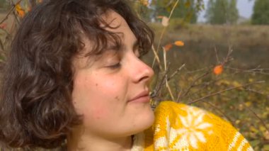 Kamera gülümseyen güzel kız. Ağaç sarı yapraklar arasında.