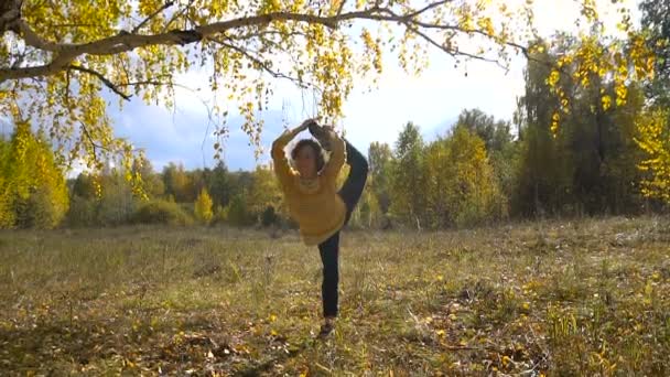 年轻女孩体操在秋天森林. — 图库视频影像