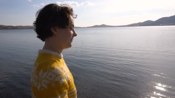 Mooi jong meisje wandelingen langs de oever van het meer in de schittering van de zon. Slow Motion — Stockvideo