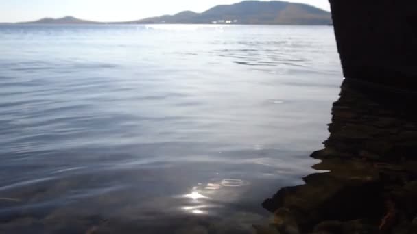Hand Mädchen im klaren Wasser des Sees. Spiel der Sonnenblendung. Zeitlupe — Stockvideo