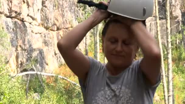 Kvinna sätter på klättring utrustning. Solig dag. Sommar — Stockvideo