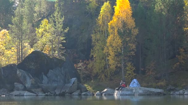 Young Couple in Love on Lake in Woods Near Tent. Panorama Autumn Leaf Sunny Day. Background of Yellow Trees. — Stock Video