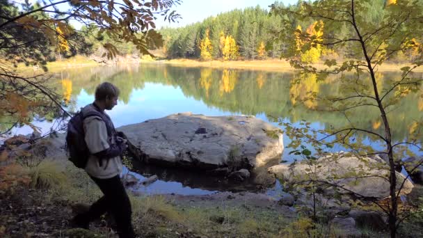 Jonge toeristen paar liefhebbers op Forest Lake. Herfstblad vallen zonnige dag. Achtergrond Water geel bomen. — Stockvideo