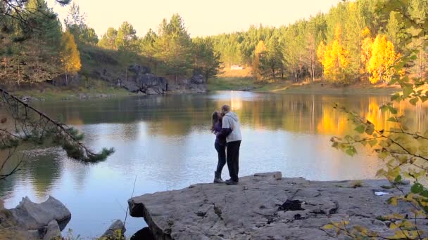 Pareja de amantes abrazándose en el otoño del lago — Vídeo de stock