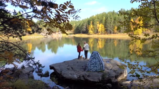 Дівчинка і хлопчик грають з собаками-туристами. Осінній намет — стокове відео