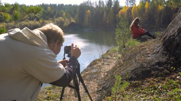 Dívka s pes pózuje pro fotografie. Na podzim jezero Beach — Stock video