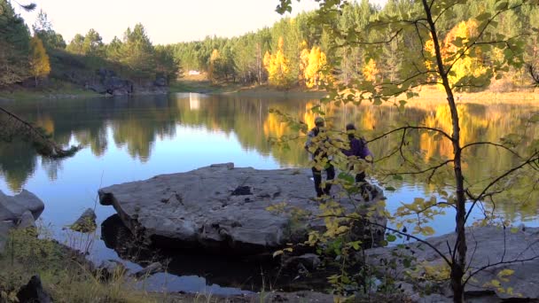 Paar liefhebbers omarmen in de herfst van Lake — Stockvideo