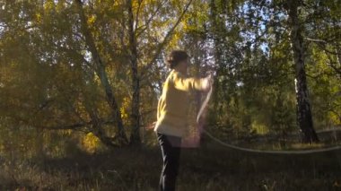 Ağır çekim kız akrobasi arka plan Leaf Fall. Güneşli gün.