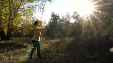 Ağır çekim kız akrobasi arka plan Leaf Fall. Güneşli gün.