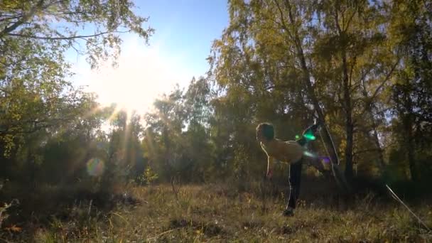 Långsam rörelse akrobatik ung flicka hösten skogen solig dag. — Stockvideo