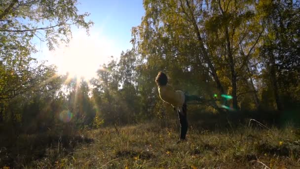 Langzame motie acrobatiek Young Girl herfst bos op zonnige dag. — Stockvideo