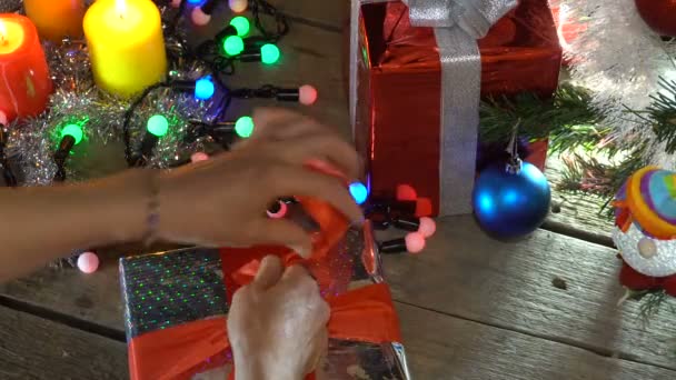 Frau verpackt Weihnachtsgeschenke unter Weihnachtsbaum — Stockvideo