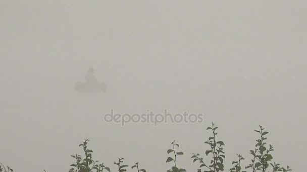 Barca con un pescatore su una nebbia nebbiosa al mattino — Video Stock