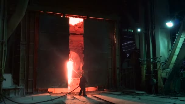 Виробництво сталі в конвертор. Силует працівника на фоні шиї. — стокове відео