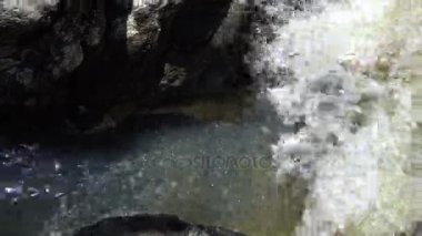 Şeffaf parlak güneşli bir günde bir dağ dere Close-Up Streams.