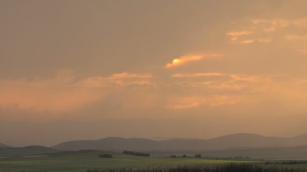 Timelaps puesta del sol en hermosas nubes rosadas contra el fondo de las montañas — Vídeos de Stock