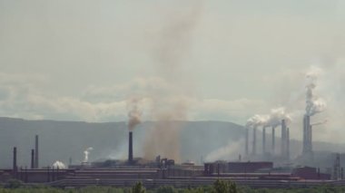 Endüstriyel bir kuruluş tarafından atmosfer kirliliği. Borular, büyük bir fabrika havaya renkli duman yayarlar.